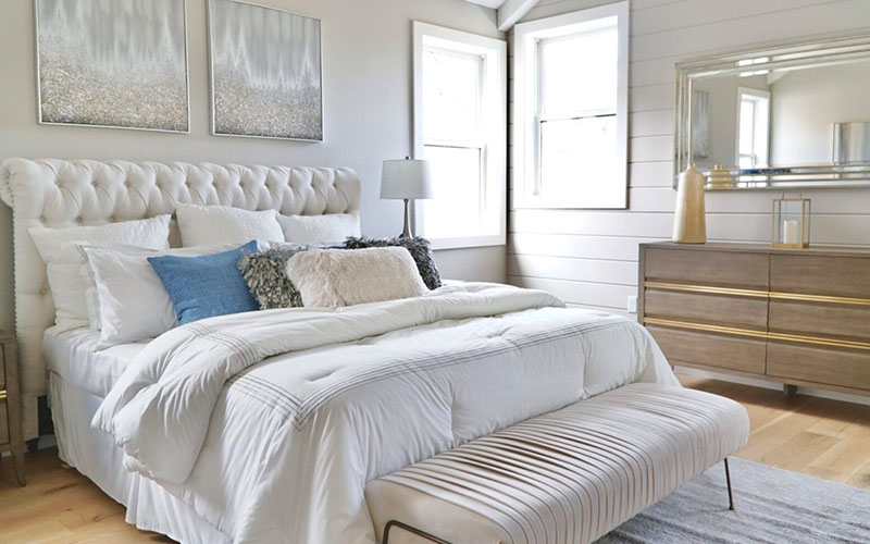 A bedroom with white walls and furniture.